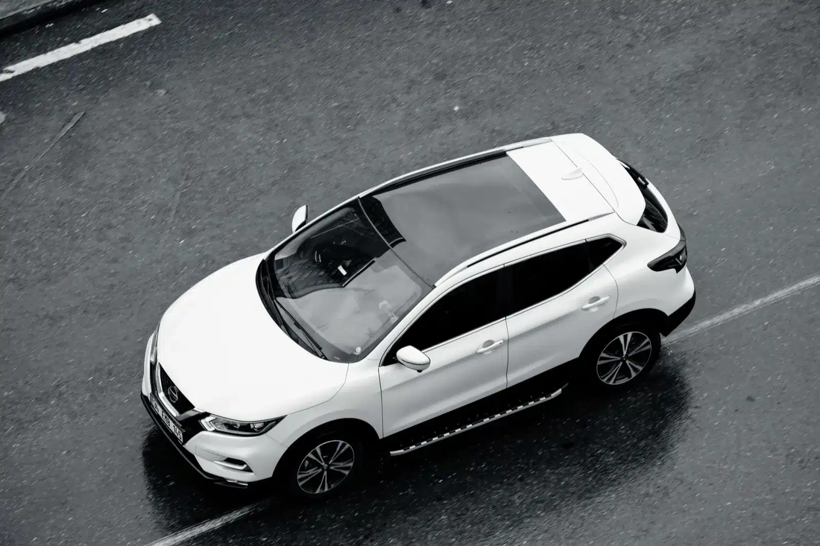 A white SUV is seen from above cruising along the wet streets of Istanbul, Turkey.