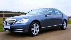 Blue Mercedes-Benz sedan parked outdoors in the UK, showcasing sleek design and luxury features.