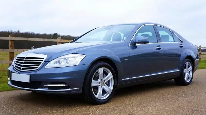 Blue Mercedes-Benz sedan parked outdoors in the UK, showcasing sleek design and luxury features.