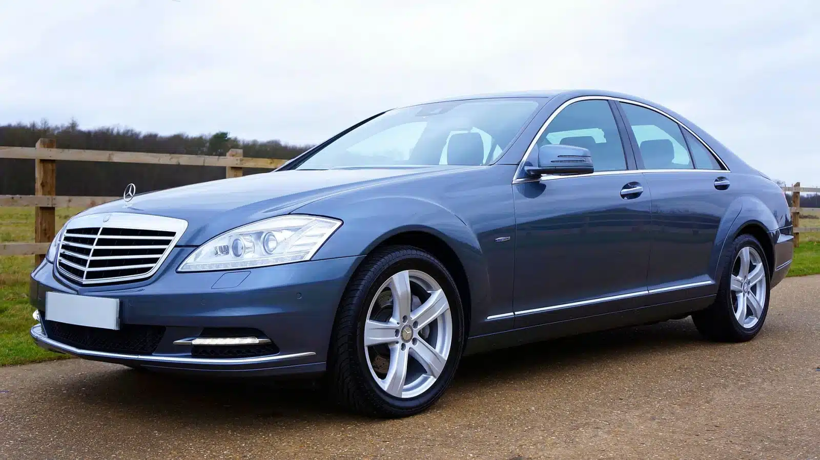Blue Mercedes-Benz sedan parked outdoors in the UK, showcasing sleek design and luxury features.
