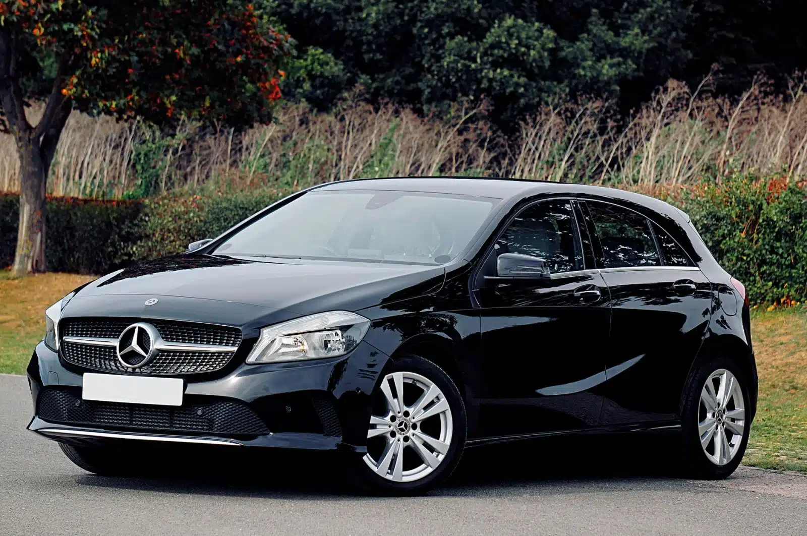 Elegant black Mercedes-Benz hatchback parked on a scenic outdoor location in the UK, showcasing luxury design.