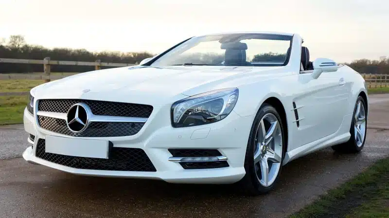 Elegant white Mercedes-Benz convertible on a scenic countryside road in the United Kingdom.