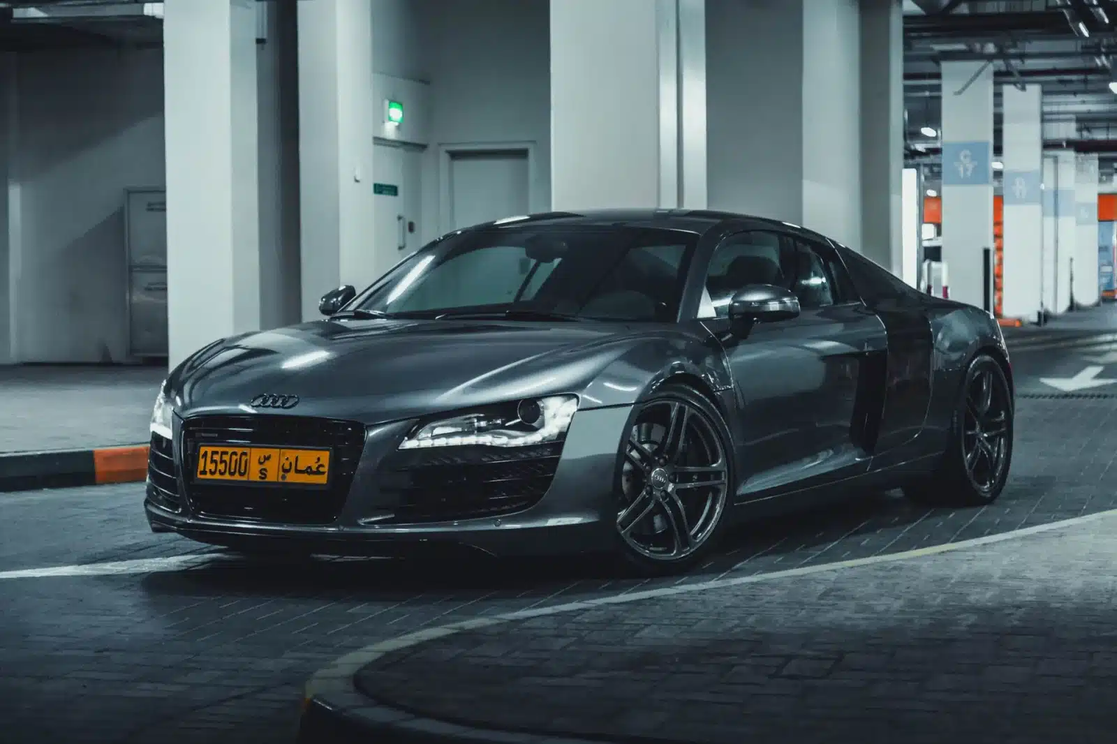 Luxurious Audi coupe parked indoors in a modern garage, showcasing sleek automotive design.