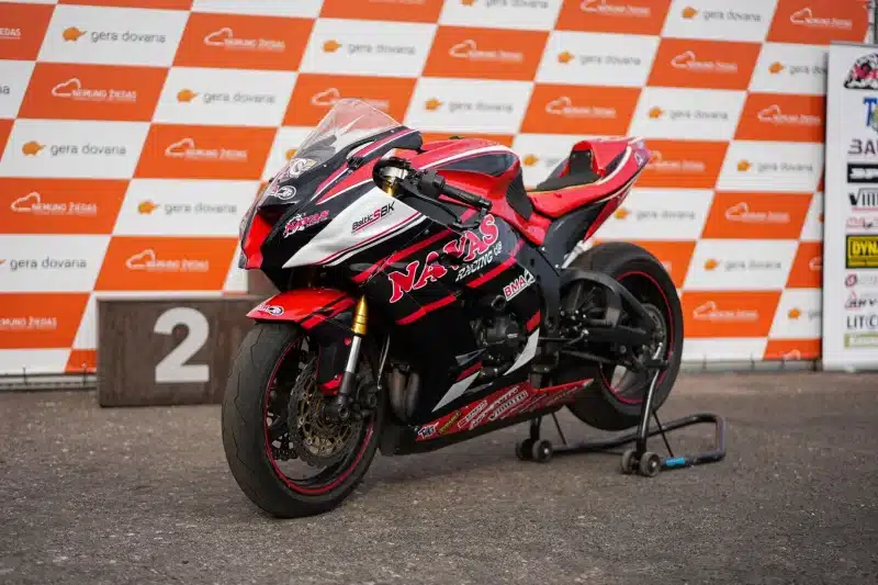 Red Kawasaki Ninja ZX-6R superbike parked at a motorsport podium event.