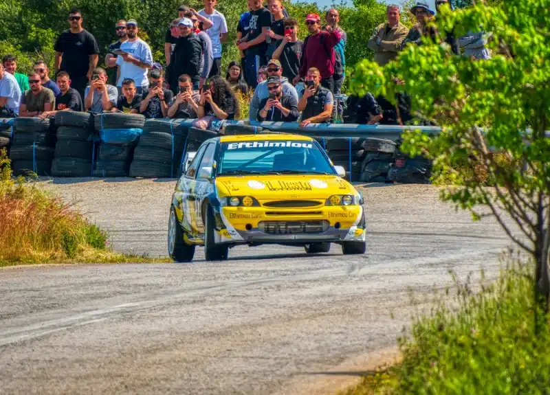 Thrilling car rally event in Ritsona, Greece with eager spectators capturing the action.