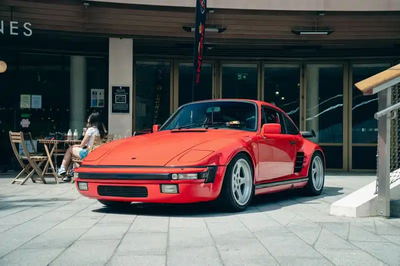 Classic red sports car parked outdoors in Southampton, England with a cafe in the background.