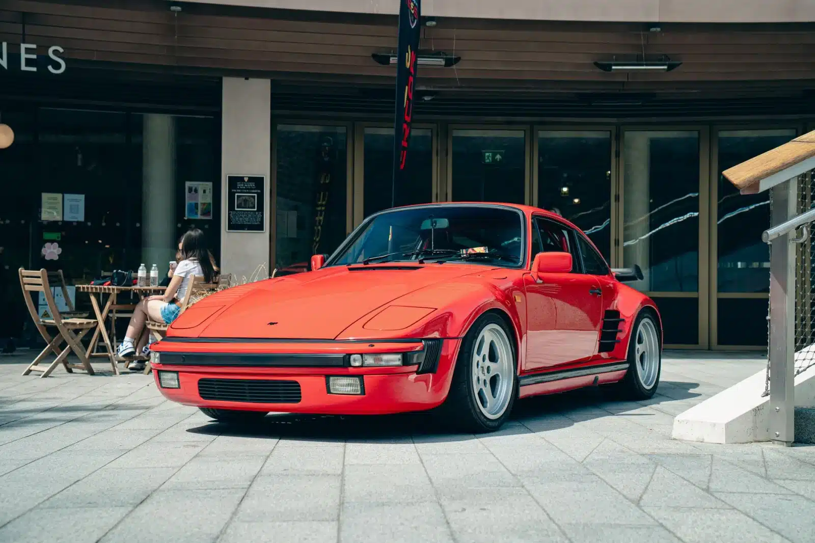 Classic red sports car parked outdoors in Southampton, England with a cafe in the background.