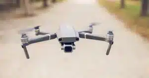 A sleek, modern drone captured flying outdoors in a serene park setting.