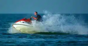 Action-packed scene of a man on a jet ski splashing through the ocean waves.