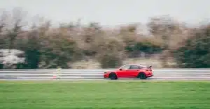 Dynamic capture of a red Honda Civic Type R speeding on Blyton track, showcasing automotive power.